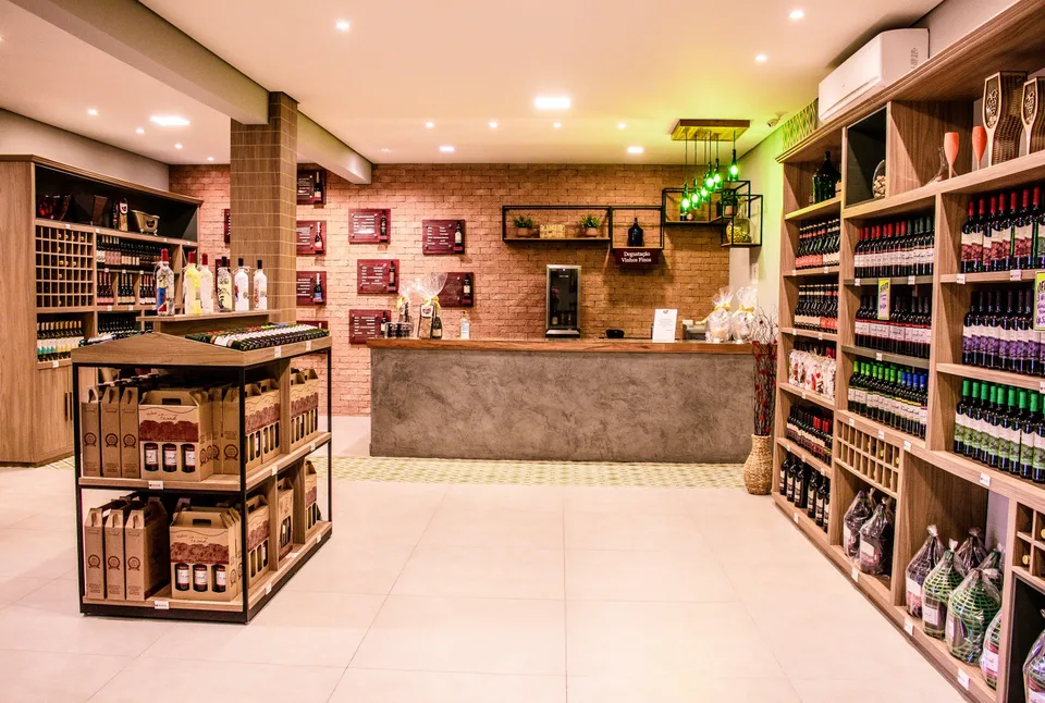 Interior da adega Vinhos Frank, com balcão e prateleiras de vinhos